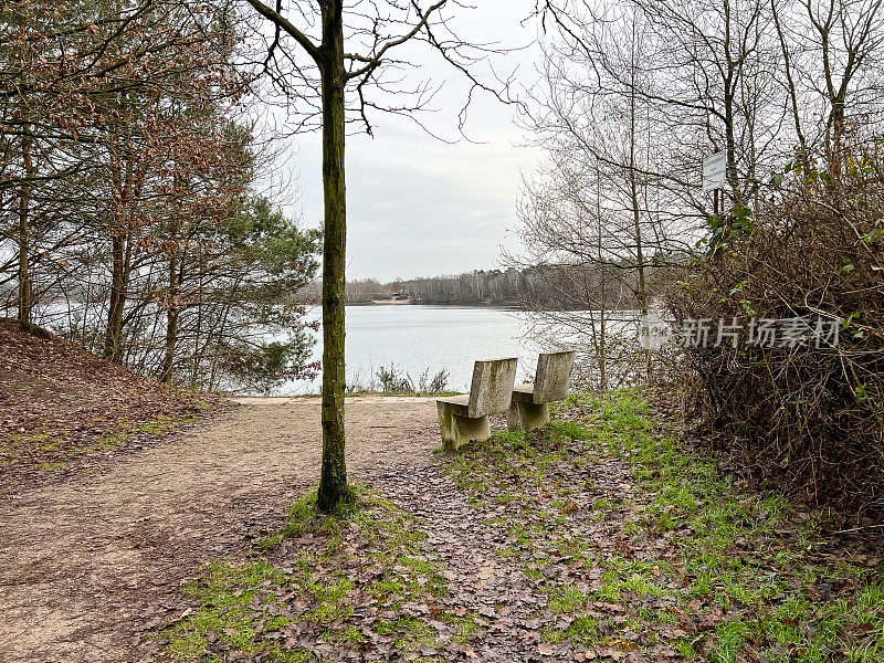 在冬天，两根石凳挨着一棵树，俯瞰着名为“Offlumer See”的湖。